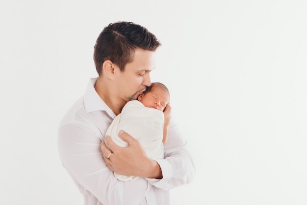 Papá sostiene al bebé en sus brazos. El concepto de educar al padre de niños pequeños, infancia feliz, una familia amigable.