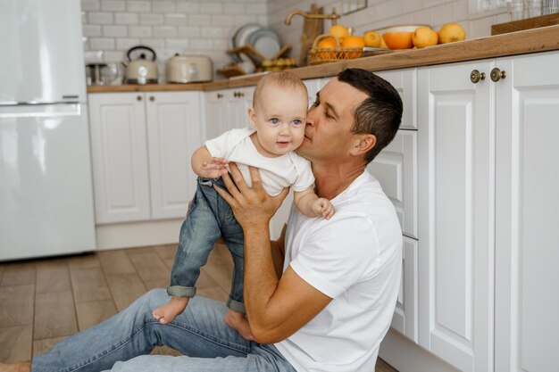 Papa spielt mit dem Baby auf dem Küchenboden