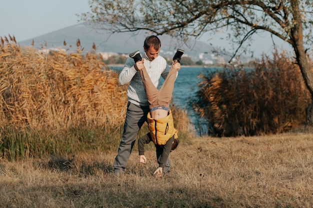 Papa spielt mit seinem Sohn am See. Herbstinhalt