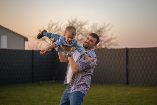 Papa spielt mit seinem Sohn im Hinterhof des Hauses