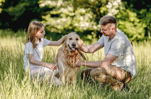 Papá y su hija juegan con el perro.