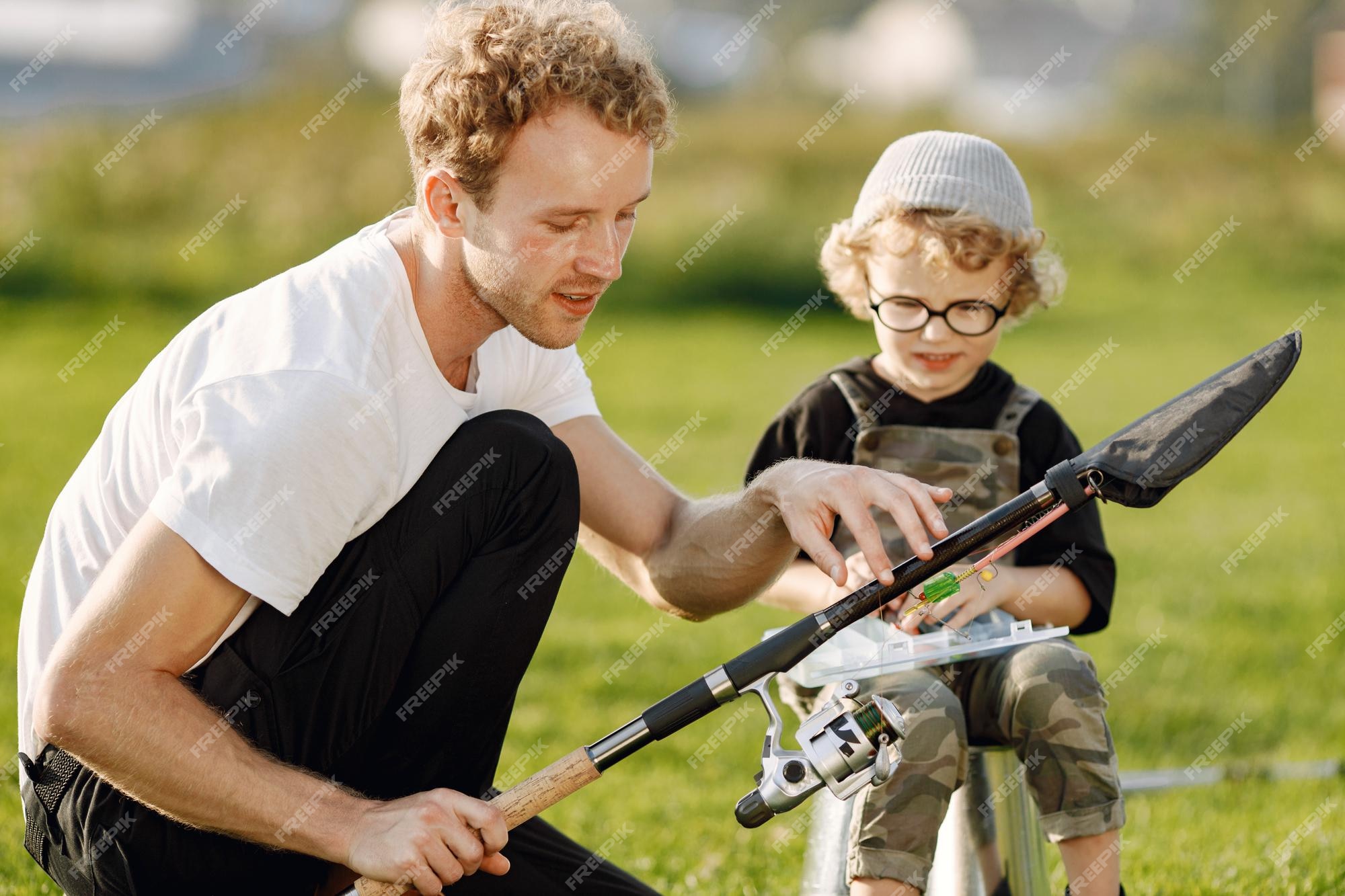 Papá y su hijo pasan tiempo juntos al aire libre. niño rizado vistiendo un de color caqui. niño sentado en un balde y escuchando a padre | Premium