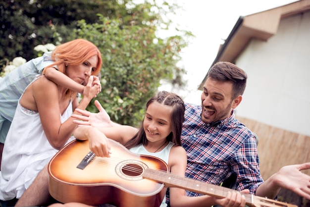 Papá tocando la guitarra para la familia.