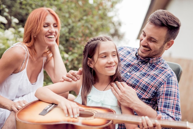 Papá tocando la guitarra para la familia.