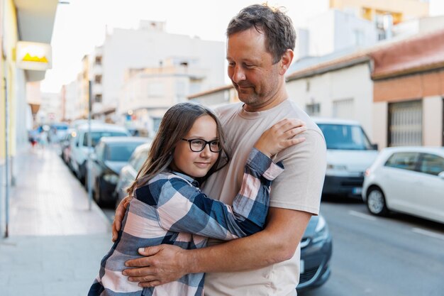Papa umarmt seine Tochter auf einer Stadtstraße