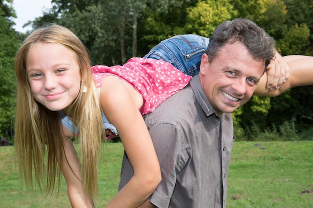 Papa und kleine Tochter haben Spaß im Park und spielen gerne