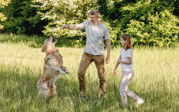 Papa und seine Tochter spielen mit Hund