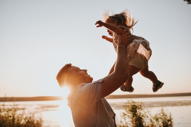 Papá vomita una pequeña hija al atardecer