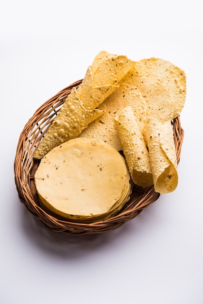 Papad o papadum gujarati en forma cruda seca con cono asado, rollo y variación plana