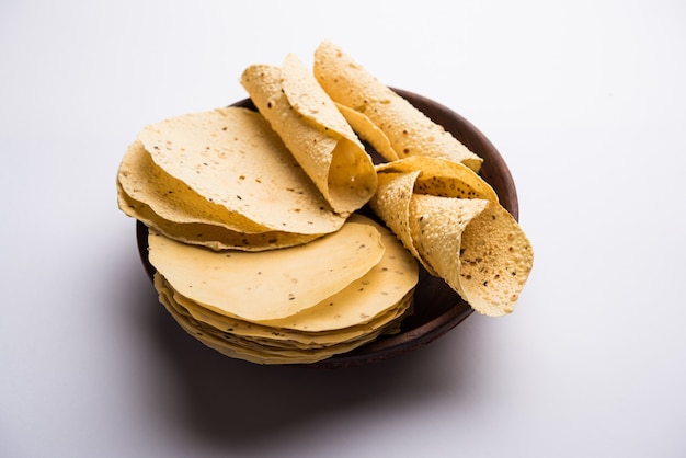 Papad o papadum gujarati en forma cruda seca con cono asado, rollo y variación plana