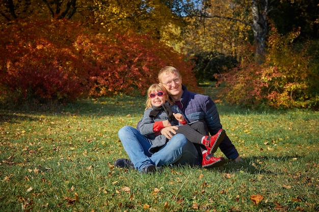 Papai brinca com a filha no parque de outono