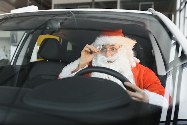 Papai Noel autêntico dirigindo seu carro moderno ao ar livre