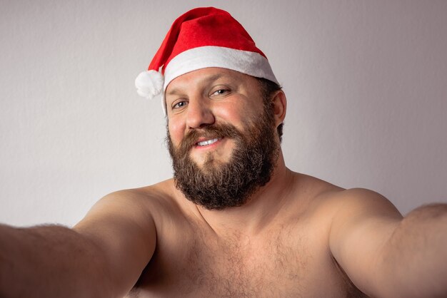 Papai noel barbudo meio nu tirando uma selfie