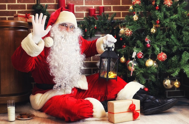 Papai Noel bem-humorado de terno vermelho e barba branca na árvore de Natal