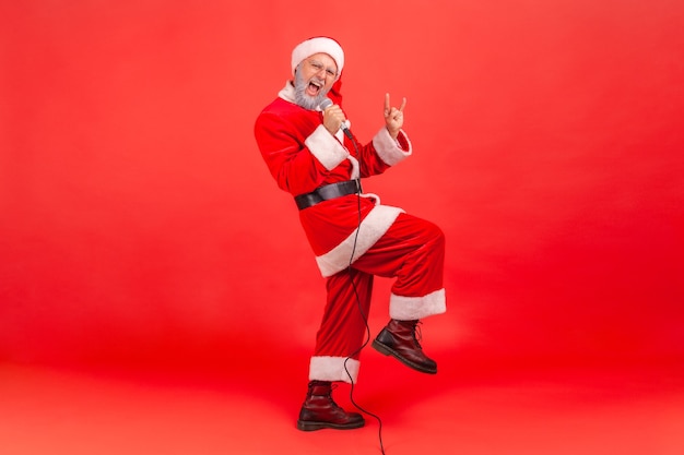 Papai Noel cantando músicas no karaokê, comemorando a festa de ano novo.