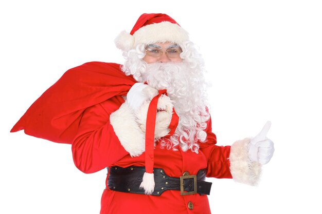 Papai Noel carregando saco grande e mostrando os polegares para cima ou ok isolado no fundo branco Retrato de corpo inteiro