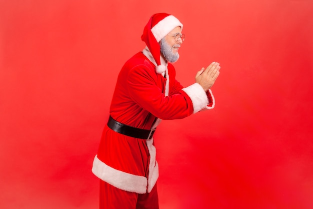 Papai noel com as mãos em oração, procurando expressão implorante, implorando ajuda, pedindo perdão.