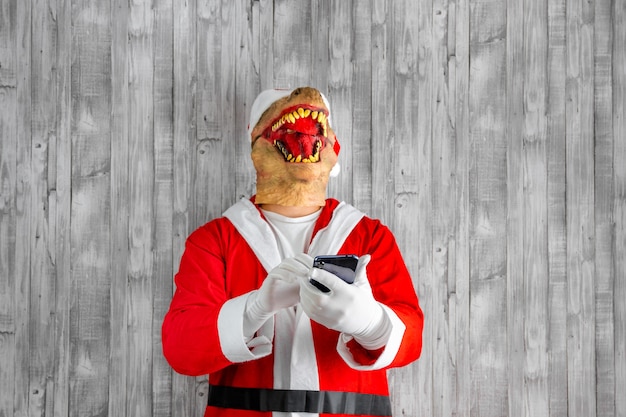 Papai Noel com cabeça de dinossauro conversando no celular