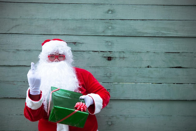 Papai noel com caixa de presente em fundo de madeiraPovo da TailândiaEnviado felicidade para criançasFeliz natalBem-vindo ao inverno