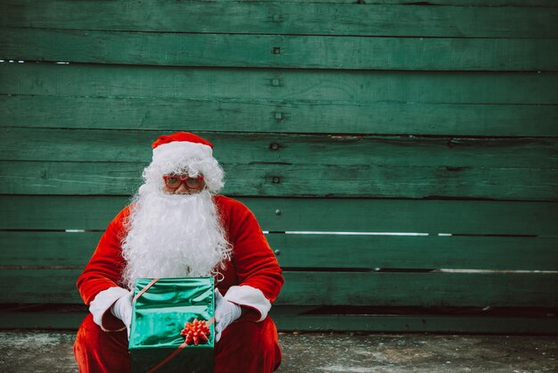 Papai noel com caixa de presente em fundo de madeiraPovo da TailândiaEnviado felicidade para criançasFeliz natalBem-vindo ao inverno