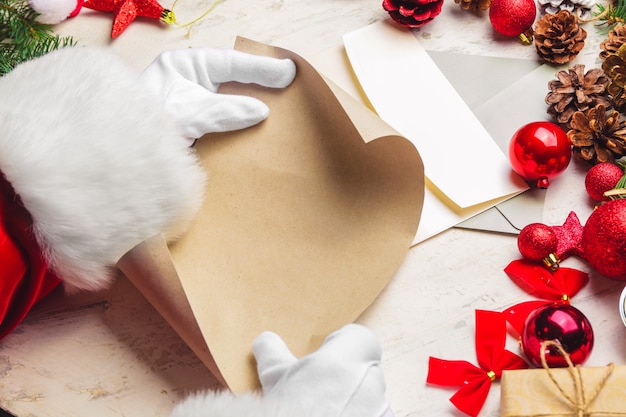 Foto papai noel com folha de papel vazia na mesa branca