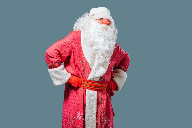 Papai Noel com um olhar cansado atento fica balançando no nariz vermelho de fundo azul