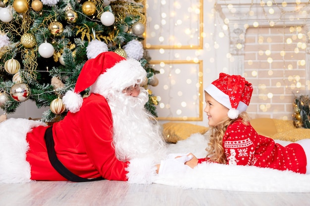 Papai Noel com uma menina na árvore de Natal