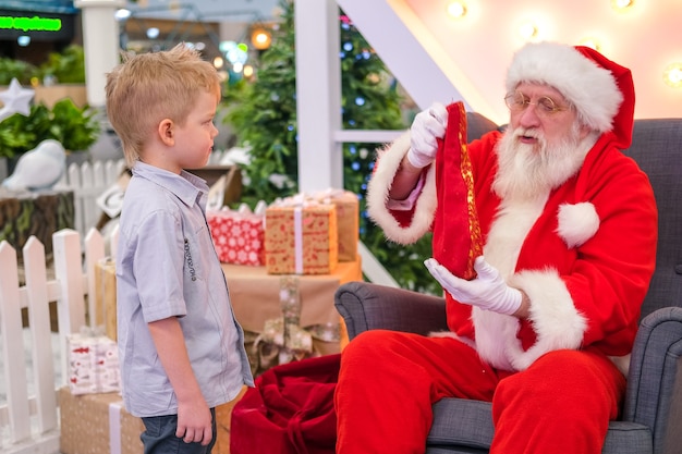 Papai Noel conversando e brincando de surpresa com as crianças no Shopping Mall