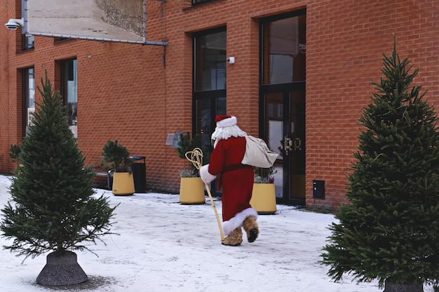Papai Noel corre para trabalhar na rua da cidade