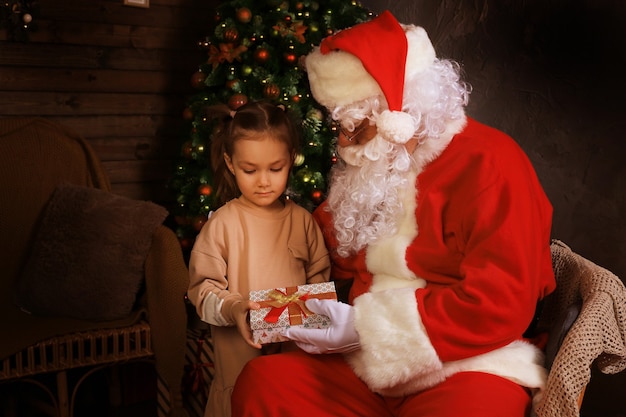 Papai Noel e criança em casa. Presente de Natal. Conceito de férias em família.