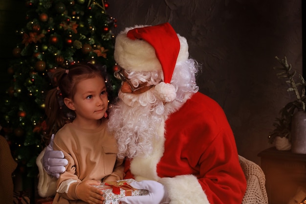 Papai noel e criança em casa. presente de natal. conceito de férias em família.