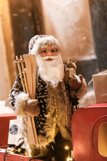 Papai Noel em um carro de brinquedo vermelho pronto para entregar presentes em clima de Natal