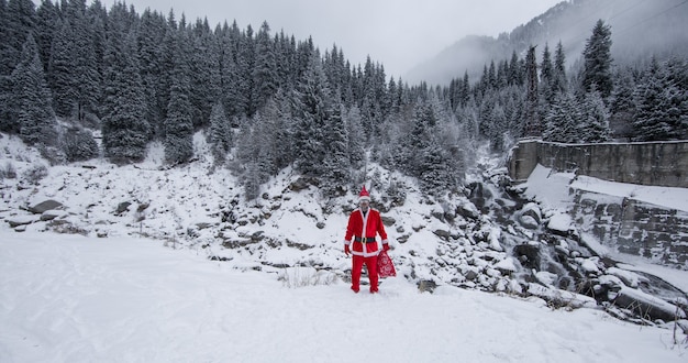 Papai Noel em uma paisagem montanhosa de inverno