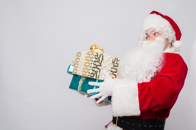 Foto papai noel engraçado em uma fantasia vermelha com presentes