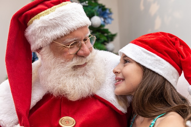 Papai Noel entregando uma caixa de presente para uma menina