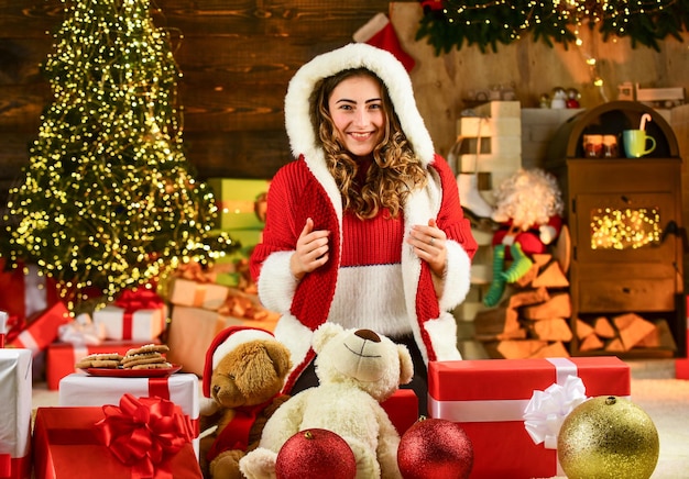 Papai Noel está perto Decore a casa Espírito de Natal Celebração do feriado em família Feliz ano novo Traje de mulher santa Venda de compras de inverno Garota feliz na árvore de natal Comemore o feriado Tradição do feriado