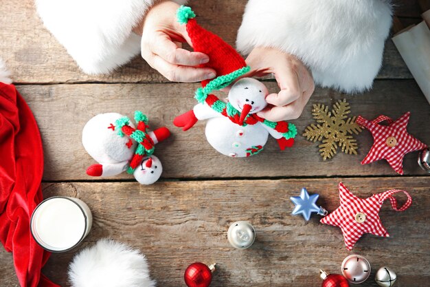 Papai Noel faz decorações de Natal em uma mesa de madeira