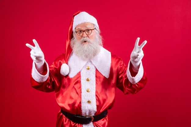 Papai Noel fazendo o sinal V na foto. Papai Noel fazendo um sinal de paz e amor e expressão facial. Véspera de Natal, Papai Noel.