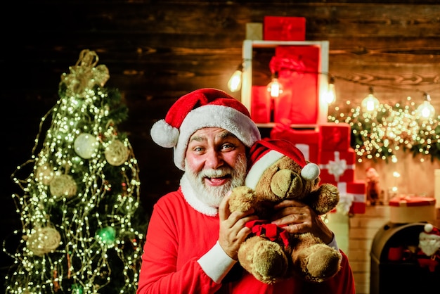 Papai Noel feliz segurando um ursinho de pelúcia Papai Noel segurando um brinquedo de pelúcia decoração de Natal Feliz Natal