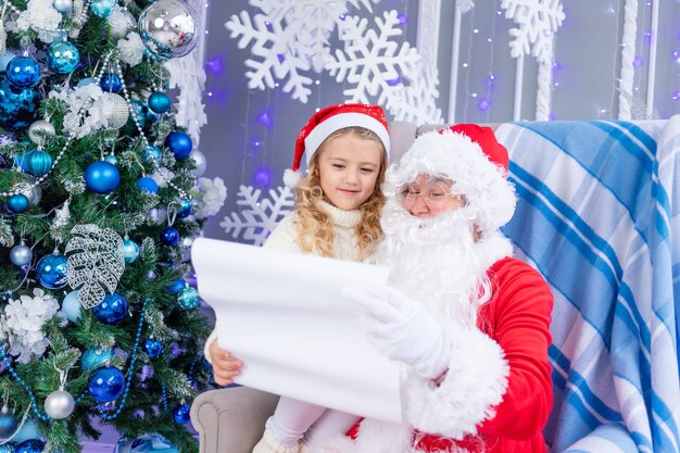 Papai Noel lê uma carta de uma criança na árvore de Natal