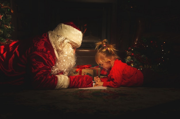 Papai Noel real está brincando com crianças perto da árvore de Natal.