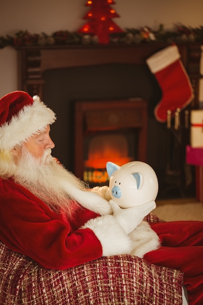 Papai Noel segurando cofrinho no Natal