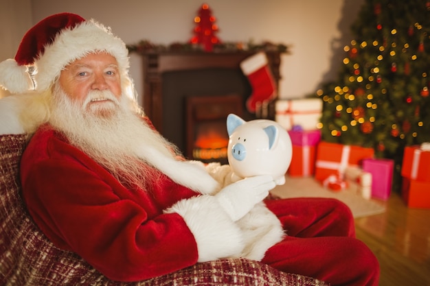 Papai Noel segurando cofrinho