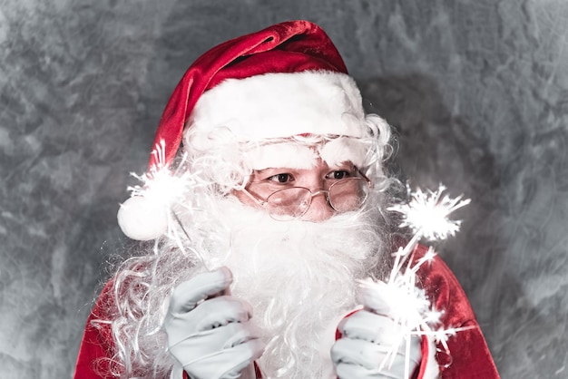 Papai noel segurando fogos de artifício para brincarfeliz natalfelicidade para as criançasbem-vindo ao invernofeliz ano novo