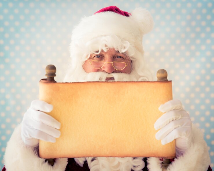Foto papai noel segurando o papel pergaminho em branco nas mãos. conceito de férias de natal