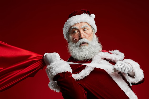 Papai noel segurando saco com presentes de natal