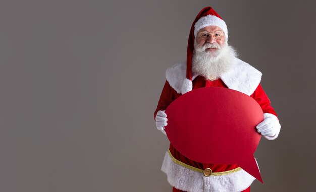 Papai noel segurando um balão de texto em branco.