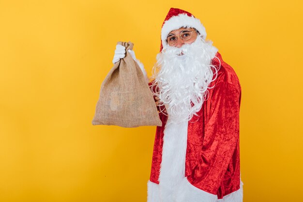 Papai Noel segurando um saco amarelo