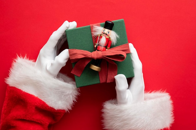 Papai noel segurando uma caixa de presente embrulhada presente contra um fundo vermelho