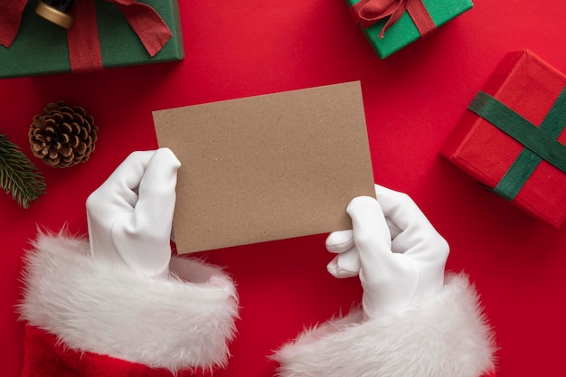 Papai noel segurando uma mensagem festiva de cartão de natal em branco simulada